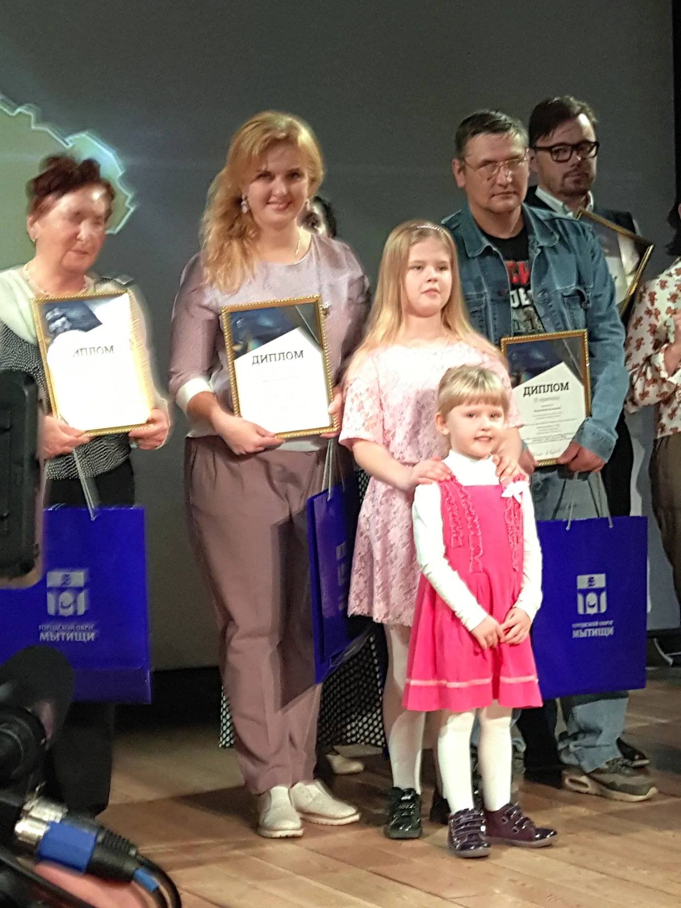 Семья с грамотами на церемонии награждения